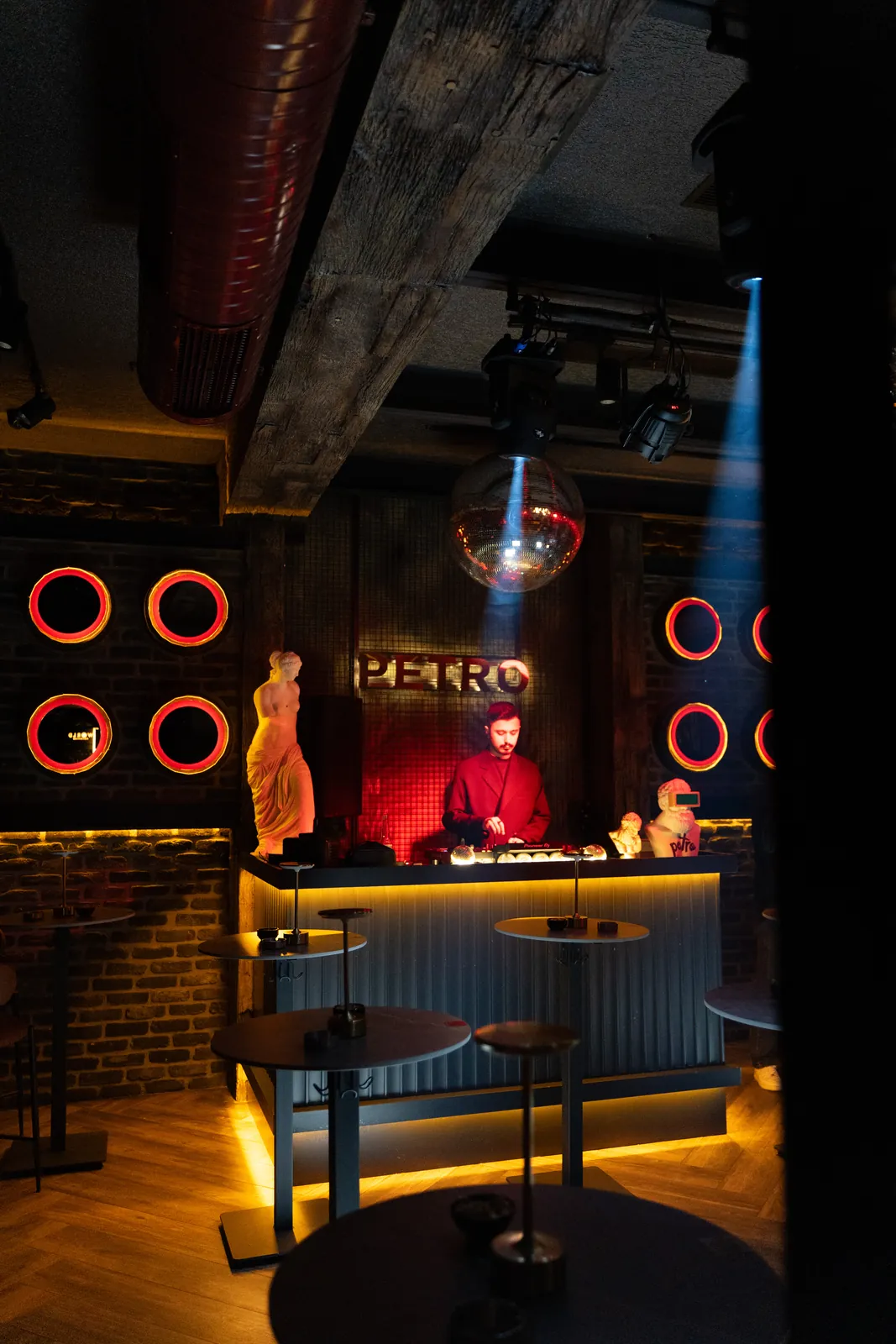 Akşamın başında salon: DJ kabini, neon halkalar, masalar
