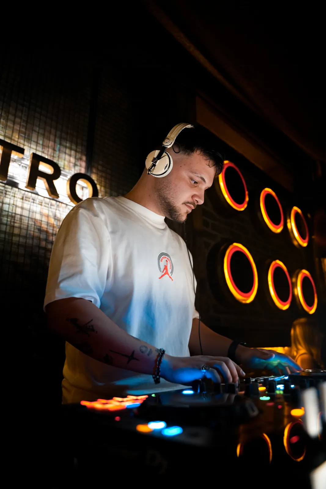 Neon halkaların önünde kulaklıklı DJ