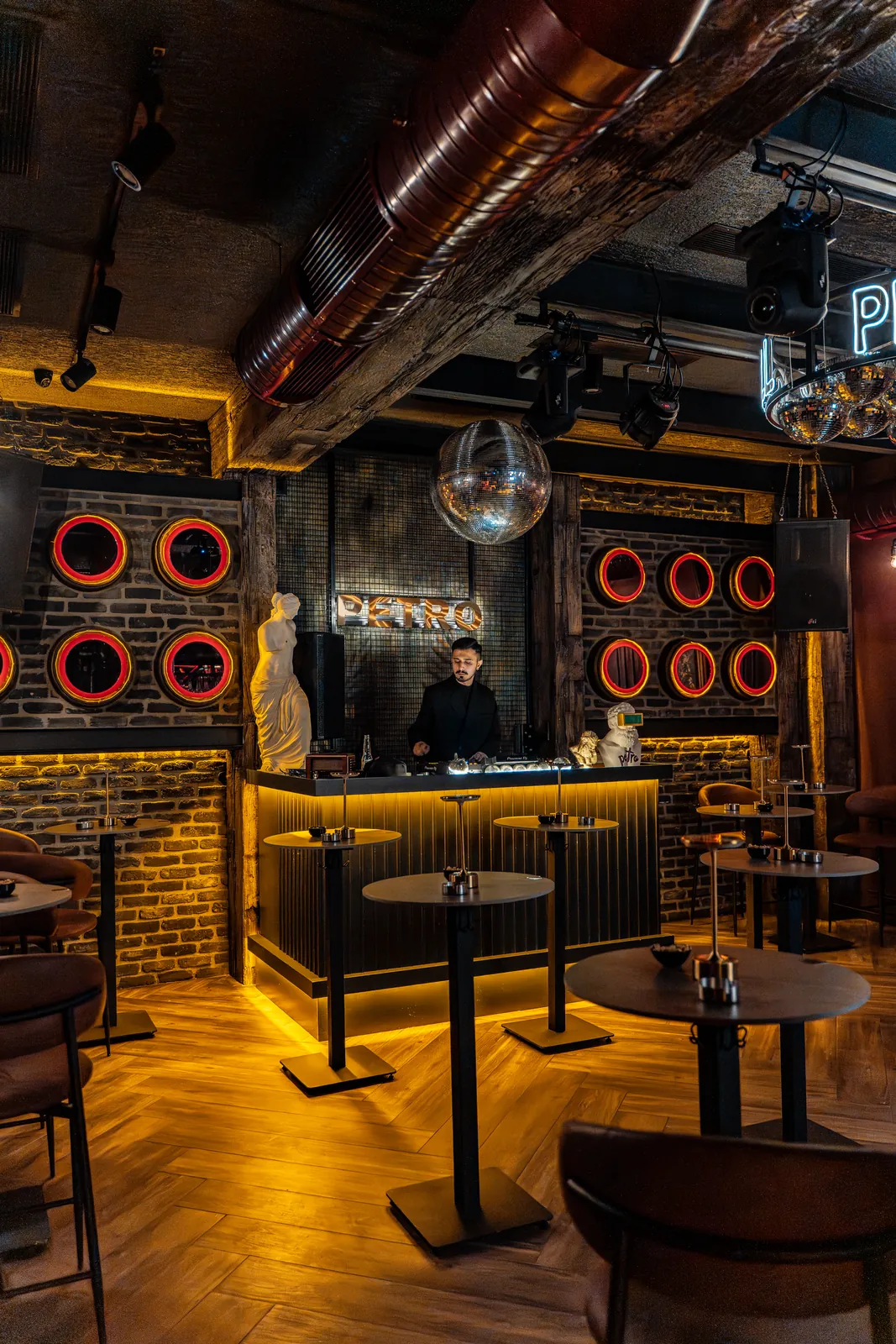 Işıkları yanmış salon, DJ kabini ve turuncu neon halkalar